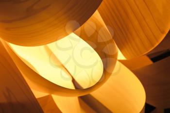 Abstract interior decoration background, lampshade made of wooden veneer with bright glowing lamp inside, closeup photo with selective focus and shallow DOF