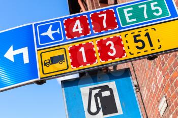 Colorful road signs with route numbers, turn arrow and gas station icon