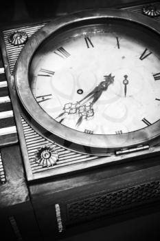 Vintage grandfather clock, decorative wooden body and white dial fragment. Close up black and white stylized photo