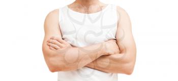 Young sporty Caucasian male torso in white shirt with crossing hands. Studio shot isolated on white