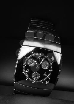 Mens chronograph watch made of high-tech ceramics with sapphire glass over black background. Selective focus