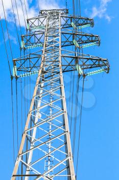 Vertical photo of lattice-type steel tower as a part of high-voltage line. Overhead power line details