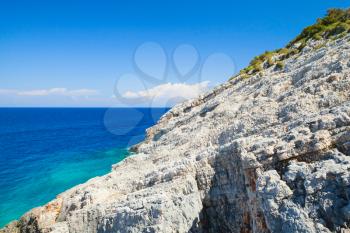 Seascape with gray coastal rocks of Greek island Zakynthos in the Ionian Sea, bright summer day