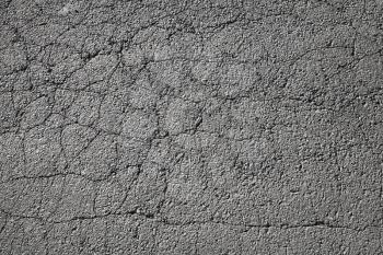 Tarmac. Cracked dark road pavement consisting of crushed rock mixed with tar. Background photo texture