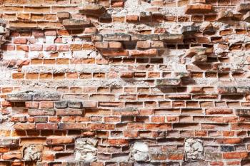 Old damaged red brick wall with cracks, background photo texture