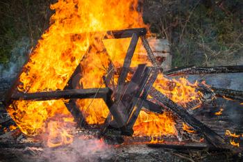 Closeup photo of burning wooden furniture in big bonfire
