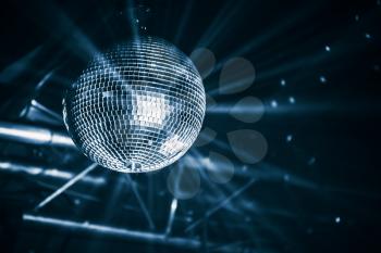 Disco ball with bright rays, blue toned night party background photo