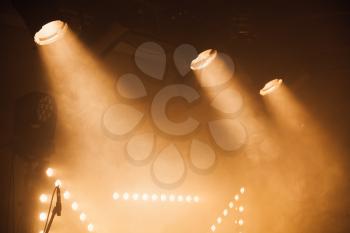 Spot lights with yellow rays in the dark, stage illumination equipment