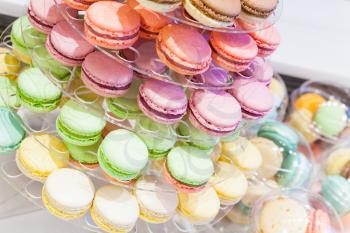 Assortment of colorful traditional French macarons lays on market counter