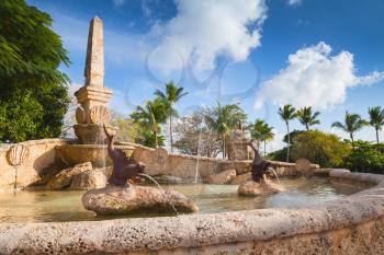 Fountain with fish sculptures. Altos de Chavon, old buildings facades, mediterranean style European village located atop the Chavon River in La Romana, Dominican Republic