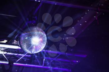 Disco ball with bright purple rays, night party background photo