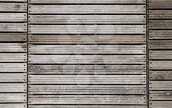Gray grungy wooden wall made of boards with rusted bolts, background photo texture