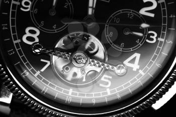 Mechanical luxury wrist watch with automatic winding, close up fragment of deal, black and white