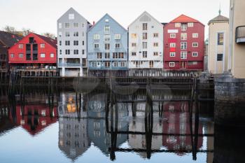 Colorful traditional wooden houses in old town of Trondheim, Norway. Coast of Nidelva river. Cold vintage tonal correction photo filer, old style effect