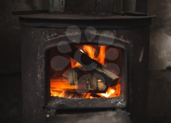 Fire burning in small black oven. Close up photo with selective focus