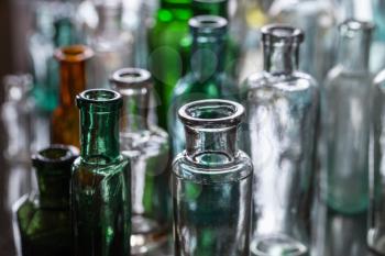 Old empty glass bottles, closeup photo with selective focus