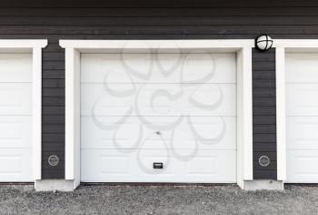 White garage wall with white closed gates, background photo texture