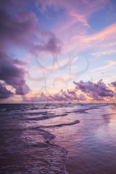 Colorful sunrise over Atlantic Ocean coast, Bavaro beach, Hispaniola Island. Dominican Republic, vertical photo