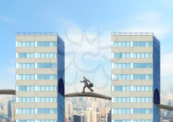 Businessman with briefcase running between two buildings