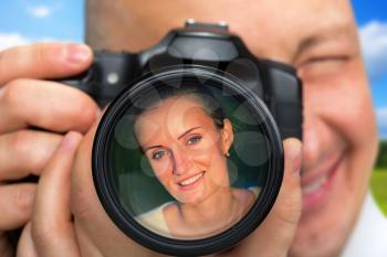 Smiling photographer capturing portrait of beautiful woman