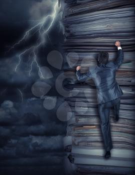 Businessmen climbing up a pile of documents at storm