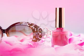 Pink nail polish with rose petals and glasses