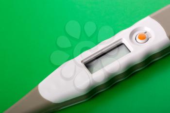 Closeup of digital thermometer on green
