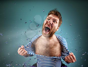 Furious man is tearing clothing on himself and are screaming