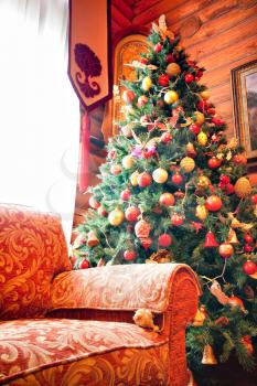 Interior of wooden chalet with christmas tree and sofa
