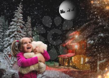 Cute girl at home holding toy bear outside in winter