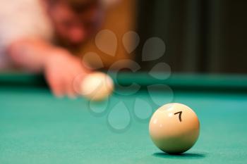 Billiard player concentrating and aiming to ball
