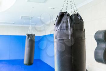 Black punching bag in the gym close up