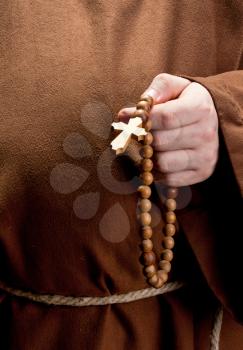 Close-up of monk hand holding wooden rosary