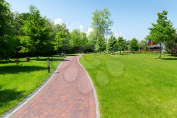 Long stone pavement alley in the park in the spring