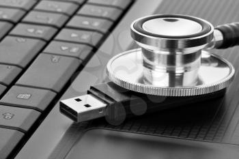 Medical stethoscope examining removable flash drive for viruses