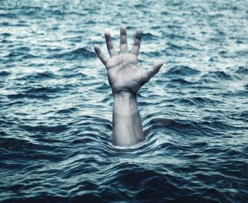 Hand of drowning man in sea asking for help