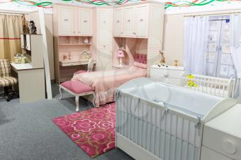 Baby's bedroom in pastel white and pink colors. Wide angle