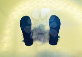Bottom view through the glass of man's shoes feet