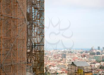 Construction site - scaffolding around new skyscraper against cityscape