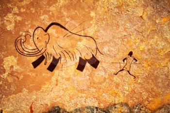 Cave painting of primitive man hunting for mammoth