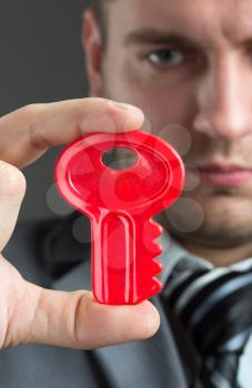 Solution concept - Businessman holding red toy key