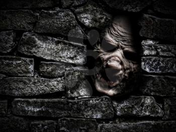 Horror monster looking out from hole in the wall