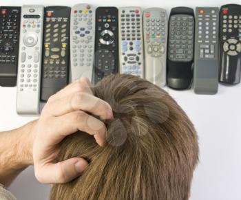 Man scratching the head and choosing remote control