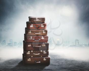 Heap of old brown suitcases over obscure background
