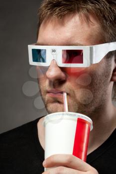 Portrait of man watching 3D movie and drinking soda