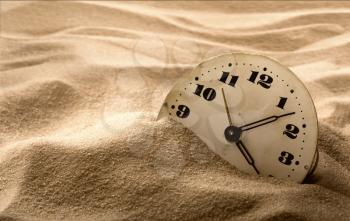 Old face of clock in sand