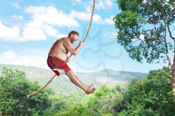 Bizarre savage flying in the air by rope in the forest