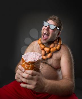 Hungry man with sausages round his neck eats a big wurst over grey