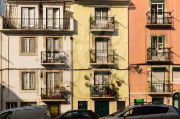 Vintage dwelling house with balconies with cars parked near it,Portugal
