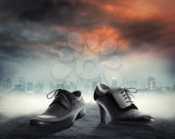 Elegant male and female dress shoes against city background